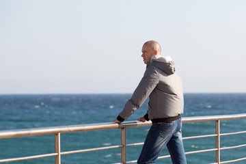 A young man standing on the sea shore