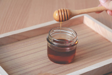 honey in glass jar on wooden table