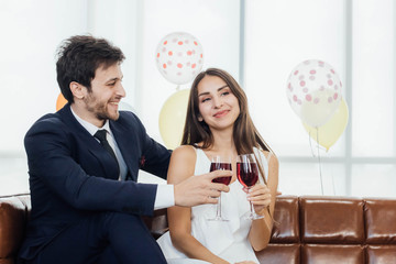 Young couple celebrating new year together, drinking wine together.