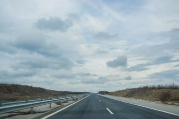 Fototapeta premium Bulgarian highway with cars and truck, asphalt road with road signs on the side, foggy weather