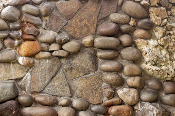 Stone wall of cobblestones covered with varnish