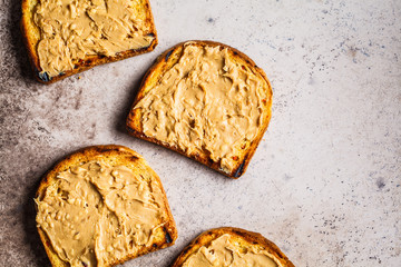 Crispy peanut butter toasts on a gray background, copy space, flat lay.