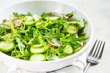 Arugula salad with cucumber and radish. Healthy food concept.