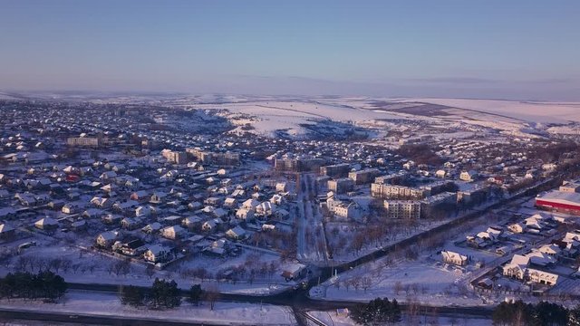Top view of city suburbs or small town nice houses on winter morning on cloudy sky background. Aerial drone photography concept.