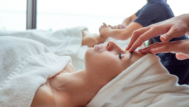 Close up of an young couple is receiving a facial massage and spa treatment for perfect skin in a luxury wellness center.