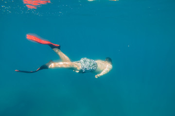 man in underwater in flippers looking at sea bottom © phpetrunina14