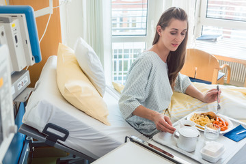 Patient in hospital lying in bed eating meal