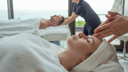 Obraz na płótnie Canvas Close up of an young couple is receiving a facial massage and spa treatment for perfect skin in a luxury wellness center.
