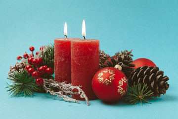 Beautiful New Year and Christmas decor. Red burning candles, balls, Christmas tree and cones.