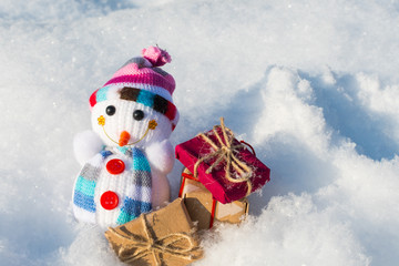 toy snowman with gifts in a snowdrift