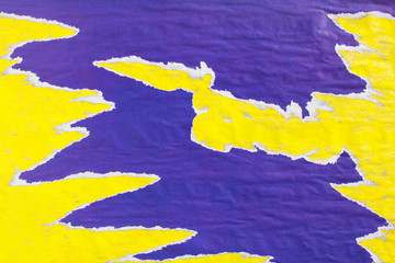 Yellow and purple old crumpled, ripped and peeling paper placards texture background.