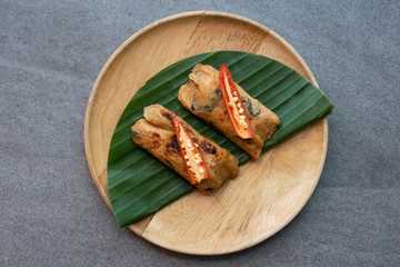Grilled fish with curry paste and coconut milk on banana leaf in wooden dish,Thai food.