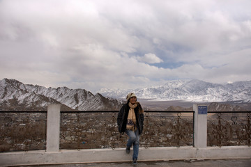 Fototapeta na wymiar Travelers thai women people travel visit and pose take photo view landscape of Leh Ladakh Village from viewpoint of Shanti Stupa on a hilltop in Chanspa at Jammu and Kashmir, India in winter season