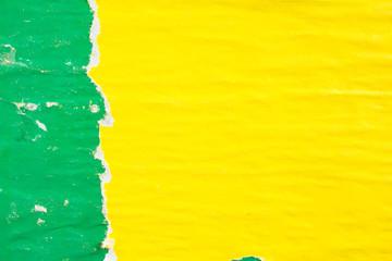 Yellow and green crumpled, torn and peeling old paper posters and placards with dirty traces of...