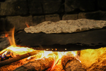 Making of pita bread in wood fire.