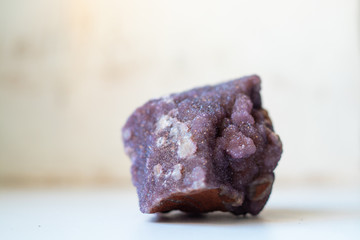 natural spessartine stone of violet color on a light background