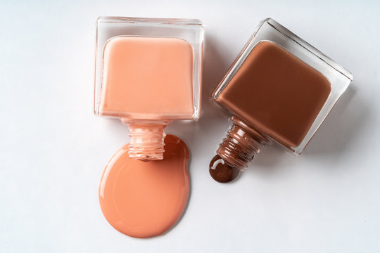 Nude Colors Nail Polish Spilled Over White Background