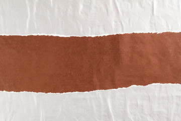Dark brown and silver grey crumpled, torn and peeling gloss paper posters glued on rough surface...