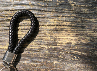 Picture of Black Leather Keychain on wood texture in dark brown tone