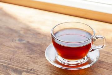 Hot cup of tea on wooden rustic table close up