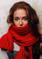 Redhead woman portrait with freckles. Portrait of woman in knitted red scarf