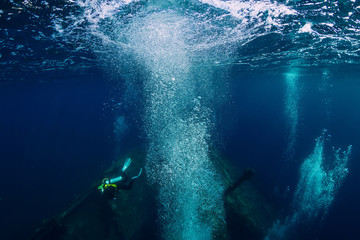Divers underwater at shipwreck in Bali. Diving in sea