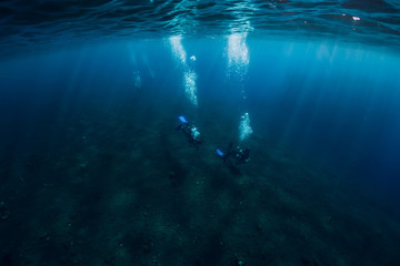 Fototapeta na wymiar Divers underwater at shipwreck in Bali. Diving in sea