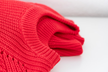 Folded Red knitted sweater on white  background.