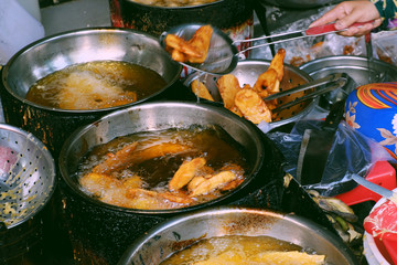boiling oil pan on charcoal stove, crispy snacks cake powder