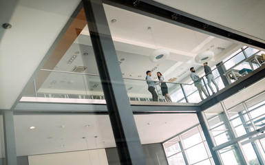 Group of business people walking and taking at stairs in an office