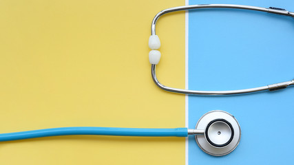 close up of stethoscope on yellow and blue background     