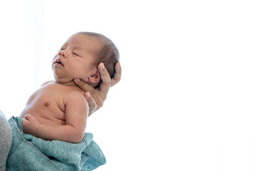 Happy young asian woman mother holding her sleepy adorable newborn baby girl in her arm. Cute newborn baby child relax sleeping in mother hands. Mother day and newborn baby infant health care concept.