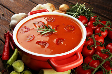 Tomato and fresh rosemary soup with garlic, cracked papper corns, served with cream. Homade tomato soup for dinner