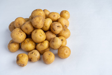 Pile  of yellow potatoes on a white background