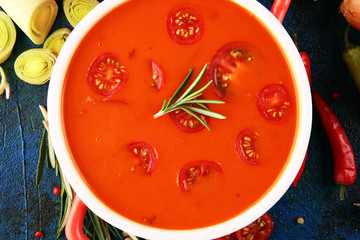 Tomato and fresh rosemary soup with garlic, cracked papper corns, served with cream. Homade tomato soup for dinner