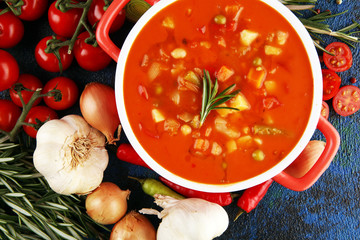 Minestrone soup in a bowl on a light table, top view. Italian soup with pasta and seasonal vegetables. Delicious vegetarian food concept.