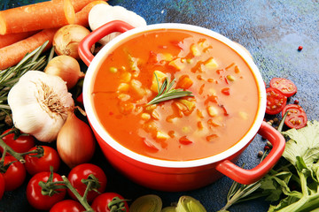 Minestrone soup in a bowl on a light table, top view. Italian soup with pasta and seasonal vegetables. Delicious vegetarian food concept.