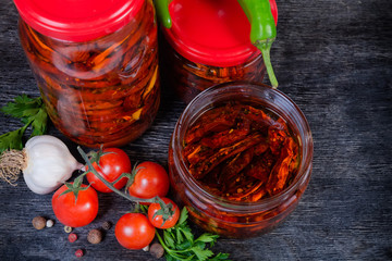 Sundried tomatoes in olive oil in glass jars among ingredients