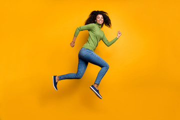 Side profile full length body size photo of positive cute nice girl running jumping to shopping mall for discount in jeans denim green sweater isolated vivid color background