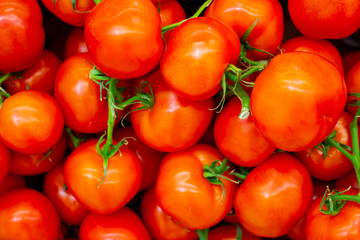 Lots of red fresh ripe tomatoes close up in the supermarket. Vegetables harvest. Food natural background . Vegetable background, concept of harvest, agriculture, veggie.