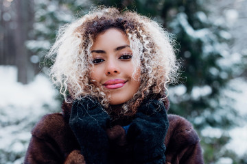 beautiful smiling young african woman in wintertime outdoor. Winter concept