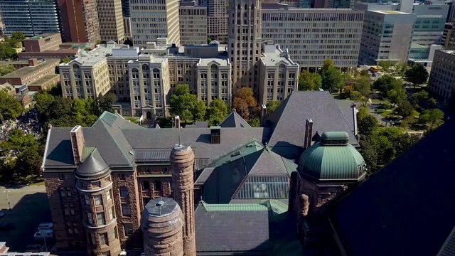 View Of Ontario Legislature And Downtown Toronto Buildings, Aerial Drone Slide. Roof Tiles And Copper Coated Towers Of Queens Park With City Architecture, Wide Daytime Exterior In 4k