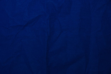 Velvet matte crumpled texture, dark blue corduroy fabric background close-up.