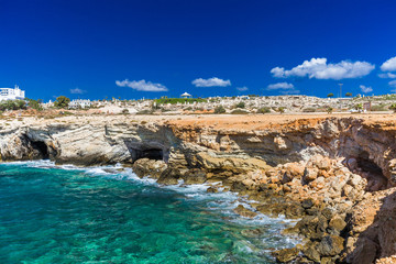 Fototapeta na wymiar Rocky shore, clear turquoise sea water and blue sky in Ayia-Napa, Cyprus, sculpture park.