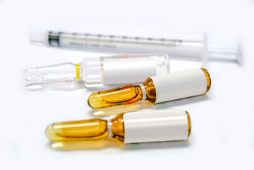 3 ml. brown Ampules of drug and plastic syringe on white background.