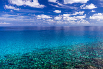 Fototapeta na wymiar The sea with clear turquoise water and blue sky with clouds on a clear day.