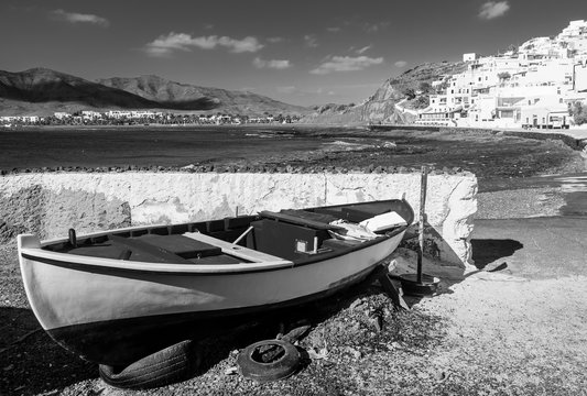 Beautiful vintage black and white image of the seaside village of Las Playitas in Fuerteventura, Canary Islands, Spain, with a boat in the foreground