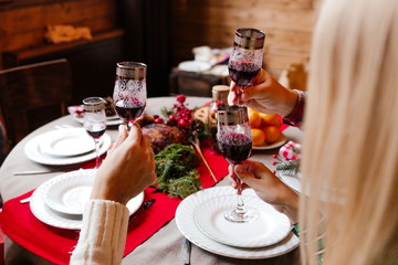 Friends celebrating the new year sitting at the table with glasses of champagne