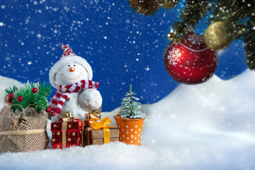 Fototapeta premium Snowman in a snowdrift with gifts for Christmas and New year