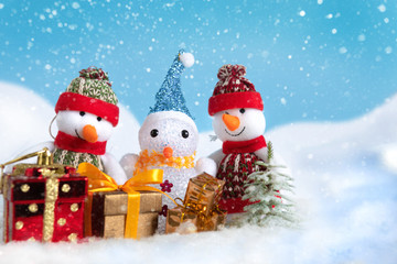 Snowman in a snowdrift with gifts for Christmas and New year